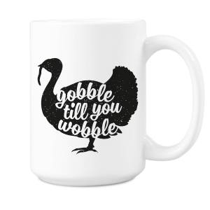 Peut inclure: Mug en c&eacute;ramique blanche avec une silhouette noire de dinde et le texte "gobble till you wobble".