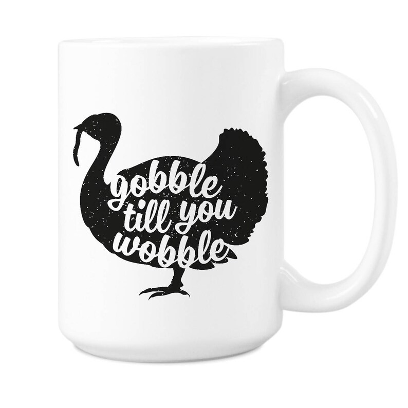 Peut inclure: Mug en c&eacute;ramique blanche avec une silhouette noire de dinde et le texte "gobble till you wobble".