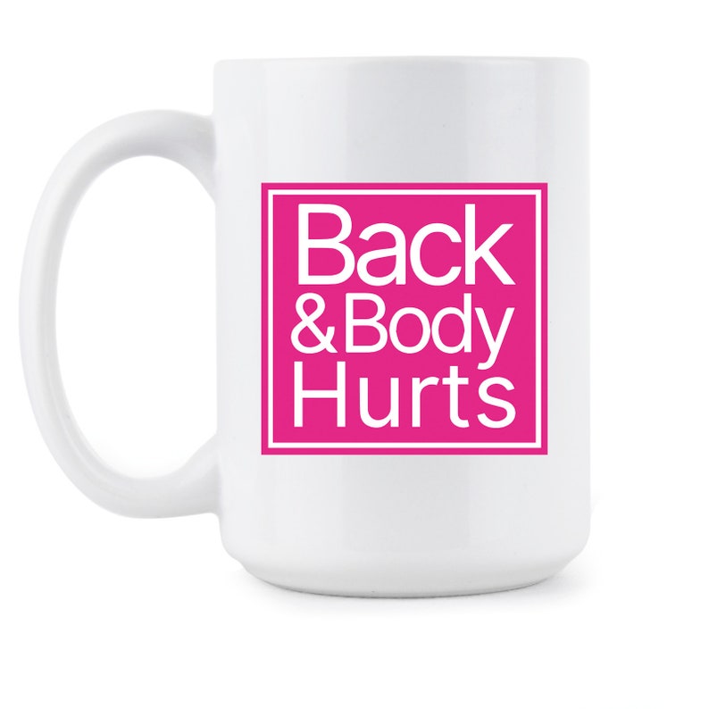 May include: White ceramic coffee mug with a pink square that says "Back & Body Hurts" in white text.