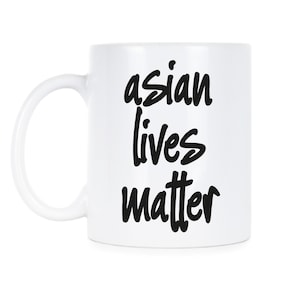 Puede incluir: Taza de café de cerámica blanca con texto negro que dice "asian lives matter".