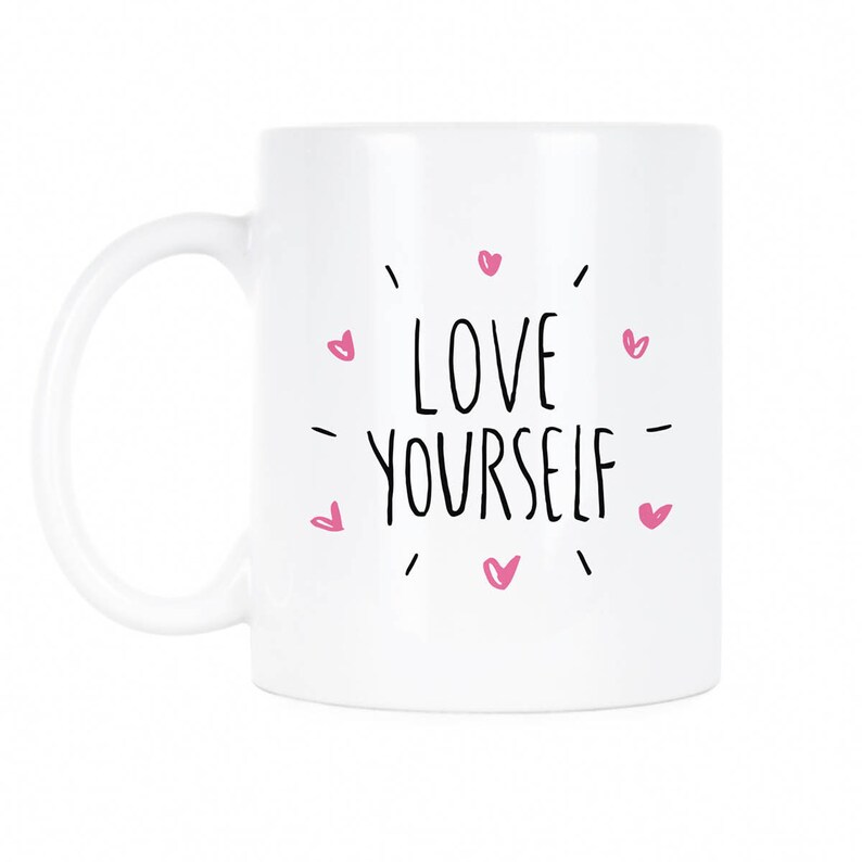 May include: White ceramic mug with a black inscription that reads "LOVE YOURSELF" surrounded by pink hearts.