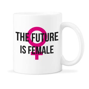 Puede incluir: Taza de cerámica blanca con un símbolo femenino rosa y el texto "THE FUTURE IS FEMALE" en negro.