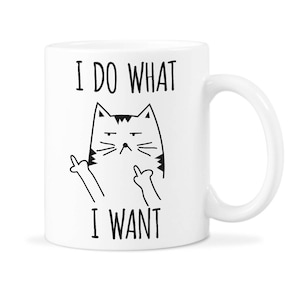 May include: White ceramic coffee mug with a black and white illustration of a cat giving the middle finger. The text "I do what I want" is printed on the mug.