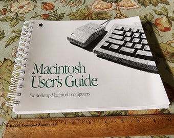 May include: A white spiral bound book with a green title that reads "Macintosh User's Guide for desktop Macintosh computers". The cover features a black and white illustration of a mouse and keyboard.