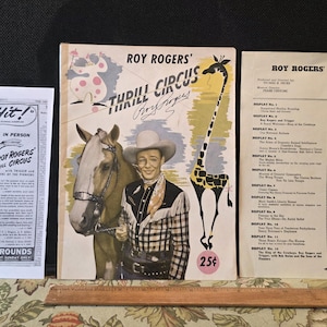 May include: Vintage Roy Rogers Thrill Circus memorabilia, including a program, a flyer, and a booklet. The program features a giraffe illustration and the text "25¢". The flyer advertises "A Giant Hit!" at Polo Grounds.