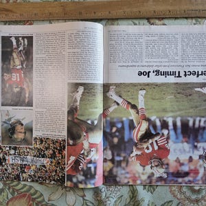 May include: A newspaper spread featuring action shots of a football game. The headline reads "Perfect Timing, Joe." The players are wearing red and gold uniforms. The image also includes a photo of a crowd holding a banner that says "THANK WALSH."