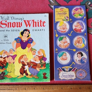 May include: A vintage "Walt Disney's Snow White and the Seven Dwarfs" Little Golden Book and a sheet of Snow White stickers. The book features a colorful illustration of Snow White and the dwarfs. The sticker sheet has images of the characters.
