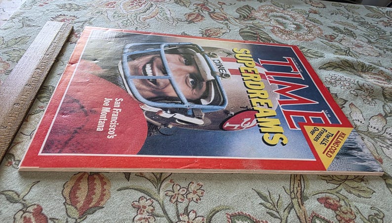 May include: A vintage TIME magazine cover featuring San Francisco's Joe Montana. The cover has a red border with the TIME logo and the headline "SUPERDREAMS." The image shows a football player in a helmet.