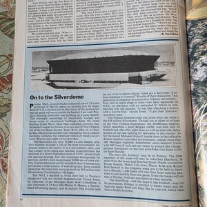 May include: A black and white photograph from Time Magazine, January 25, 1982, featuring the Silverdome stadium. The stadium is a large, enclosed structure with a distinctive roof, set against a backdrop of text.