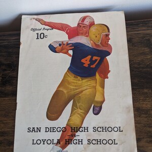 May include: Vintage football program cover featuring two players in action. The cover has the text "Official Program 10c" and "San Diego High School vs Loyola High School". The date of the game is October 17, 1947.