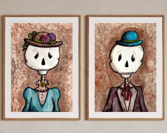 May include: Two framed watercolor paintings of skeletons dressed in vintage clothing. The skeleton on the left is wearing a blue dress and a brown hat with flowers. The skeleton on the right is wearing a purple suit and a blue hat.
