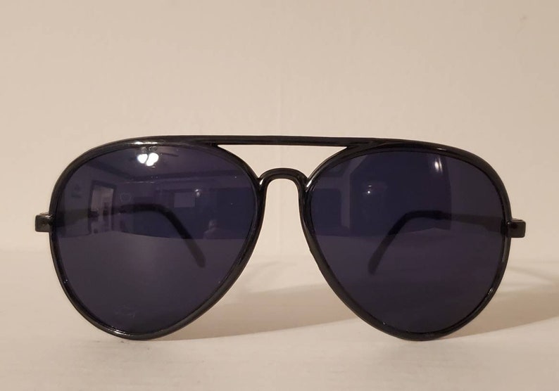 May include: Black aviator sunglasses with dark lenses. The sunglasses have a metal frame and are in good condition.