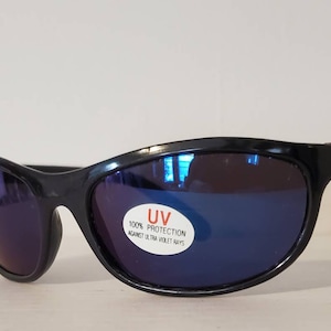 Op de afbeelding: Zwarte zonnebril met blauwe gespiegelde glazen. De zonnebril heeft een sticker met de tekst "UV 100% PROTECTION AGAINST ULTRA VIOLET RAYS".