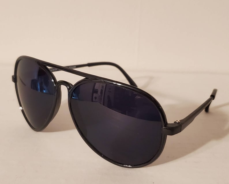 May include: Black aviator sunglasses with dark lenses. The sunglasses have a metal frame and are in good condition.