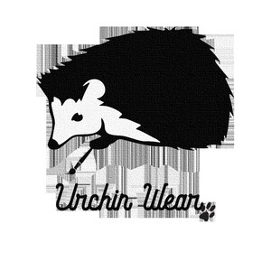 May include: Black and white illustration of a hedgehog with a paintbrush in its mouth. The text "Urchin Wear" is below the hedgehog.
