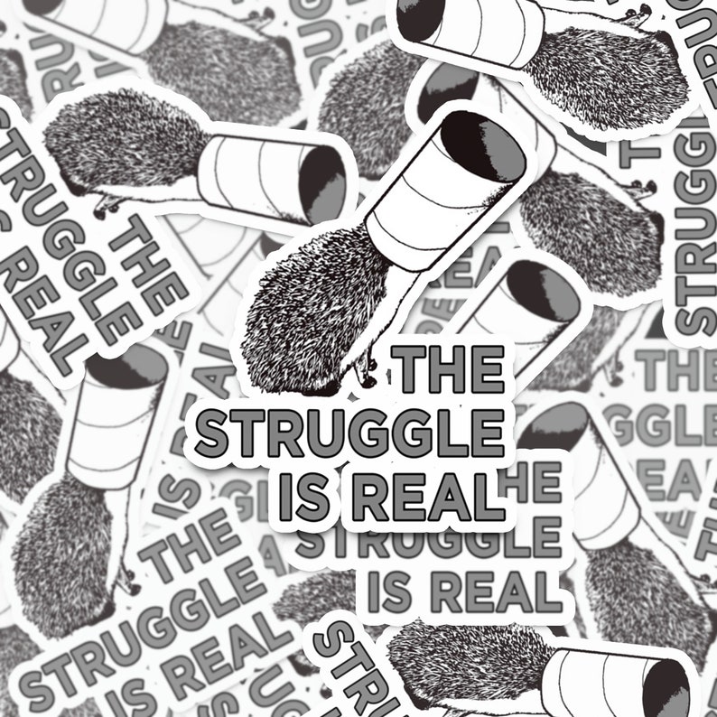 Puede incluir: Una pegatina con un erizo intentando salir de un rollo de papel higi&eacute;nico. El texto de la pegatina dice "The Struggle is Real".