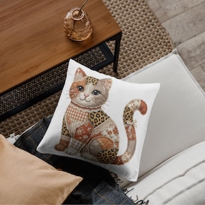 May include: A decorative square pillow featuring a patchwork cat design. The cat has a mix of patterns, including leopard print and floral patches, with a smiling face and a curled tail. The pillow is on a white background.