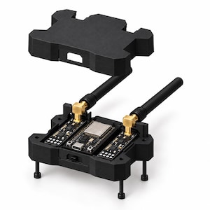 Könnte beinhalten: Eine schwarze Elektronik-Entwicklungsplatine mit einem zentralen Mikrocontroller mit USB-C-Anschluss, flankiert von zwei kleineren Platinen. Zwei schwarze Antennen mit goldfarbenen Anschlüssen sind befestigt, und eine separate schwarze Abdeckung schwebt darüber.