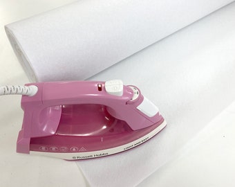 May include: A pink iron with a white handle and a white cord. The iron is on a white fabric roll. The iron has a button on the handle and a dial on the side. The iron has the text "LIGHT AND EASY" printed on the side. The iron also has the text "Russell Hobbs" printed on the side.