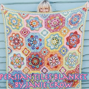 May include: A colourful crocheted blanket with a geometric pattern of flowers and stars. The blanket is made in a variety of colours, including pink, orange, yellow, blue, and green. The blanket is called "Persian Tiles Blanket by Janie Crow".
