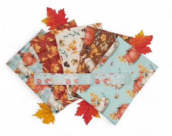 May include: A set of five fabric squares featuring a fall theme with pumpkins, leaves, and acorns. The fabric squares are in shades of brown, orange, cream, and blue. The text "Autumn Awakening" is printed on a label.