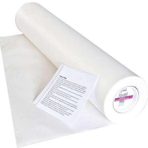 May include: A roll of white fusible interfacing with a sheet of the same material partially unrolled. A small white paper with instructions is next to the interfacing. The end of the roll has a pink and white label with the number 1152.