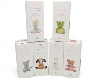 May include: Six white rectangular boxes from The Lovely World of Ricorumi mini crochet kit collection. Each box features a printed illustration of a different crocheted animal: a unicorn, frog, cat, dog, rabbit, and teddy bear, with text labels.