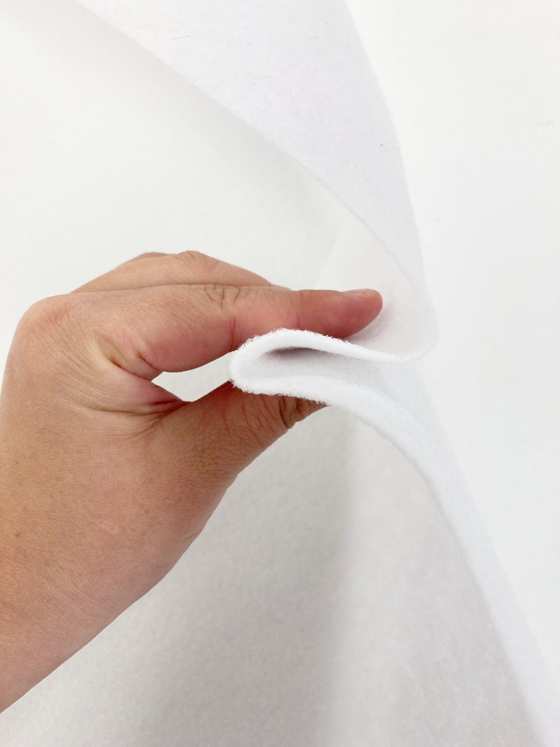 May include: White felt fabric, folded in half, showing the thickness and texture of the material.