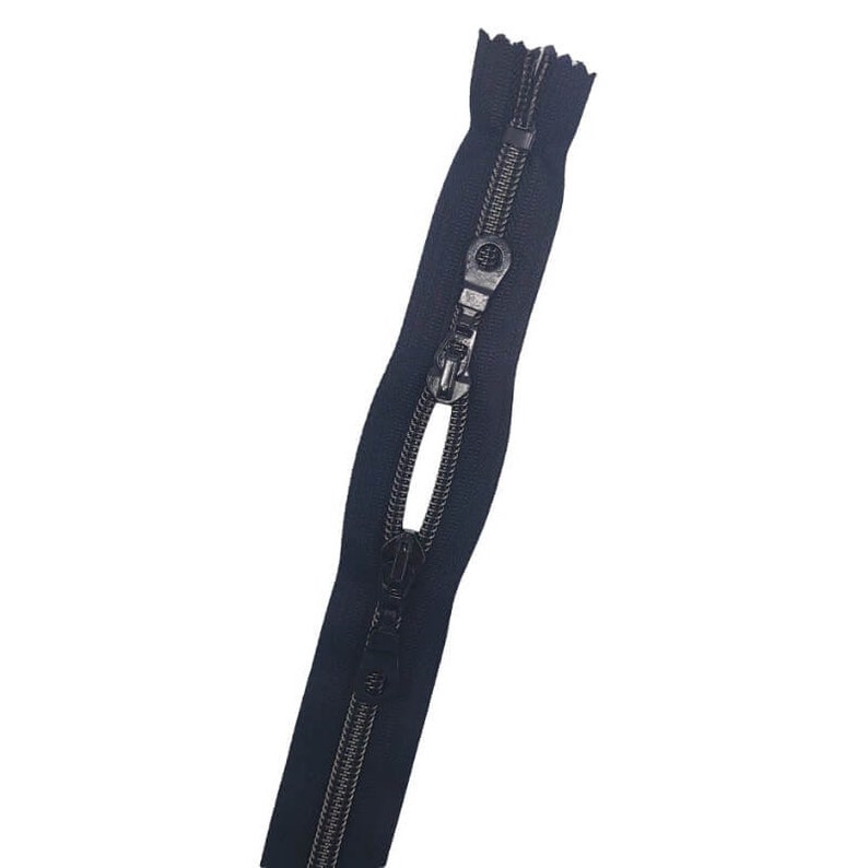 May include: A black zipper with a metal slider and a black tape. The zipper is open and the slider is in the middle of the tape.