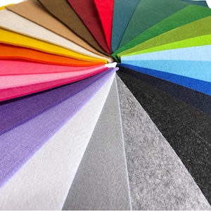 May include: A fan of 20 different colored felt fabric swatches arranged in a circle. The colors range from bright red to dark green.