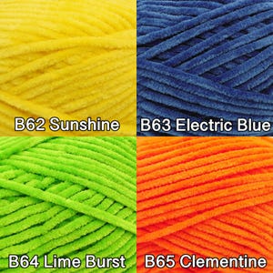 Pu&ograve; includere: Primo piano di quattro gomitoli di filato di peluche in colori vivaci. I colori sono giallo (B62 Sunshine), blu (B63 Electric Blue), verde (B64 Lime Burst) e arancione (B65 Clementine). Il filato &egrave; morbido e strutturato.