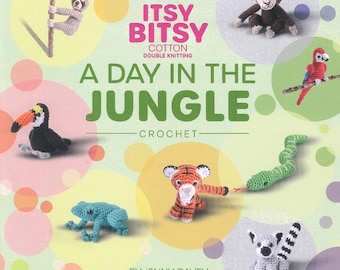 May include: A book cover featuring crochet jungle animals, including a toucan, monkey, tiger, snake, and frog. The title "A Day in the Jungle" is displayed in large green letters, with the words "Itsy Bitsy" above. The author's name is at the bottom.