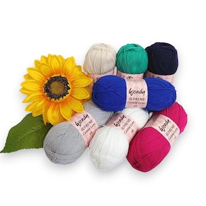 May include: Assortment of eight balls of yarn in various colours, including white, grey, blue, green, pink, and black. Each ball has a label that reads "Wendy Supreme Cotton Love DK".