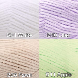 Pu&ograve; includere: Primo piano di quattro gomitoli di filato morbido e soffice in bianco, lilla, fulvo e verde mela. Ogni gomitolo &egrave; etichettato con un codice colore: B01 Bianco, B10 Lilla, B28 Fulvo e B11 Mela. Il filato sembra essere di tipo ciniglia o velluto, ideale per lavorare a maglia o all'uncinetto.