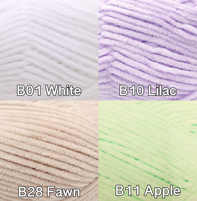 Pu&ograve; includere: Primo piano di quattro gomitoli di filato morbido e soffice in bianco, lilla, fulvo e verde mela. Ogni gomitolo &egrave; etichettato con un codice colore: B01 Bianco, B10 Lilla, B28 Fulvo e B11 Mela. Il filato sembra essere di tipo ciniglia o velluto, ideale per lavorare a maglia o all'uncinetto.