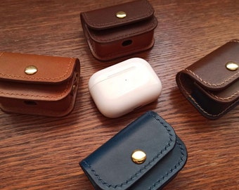 Puede incluir: Cuatro estuches de cuero para Airpods en diferentes colores: marrón, marrón oscuro, azul y blanco. Los estuches tienen una solapa que se cierra con un botón dorado.