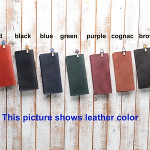 Peut inclure: Huit &eacute;chantillons de cuir suspendus &agrave; des pinces &agrave; linge sur un fond de bois blanc. Les &eacute;chantillons sont &eacute;tiquet&eacute;s avec les couleurs&nbsp;: rouge, noir, bleu, vert, violet, cognac et marron.