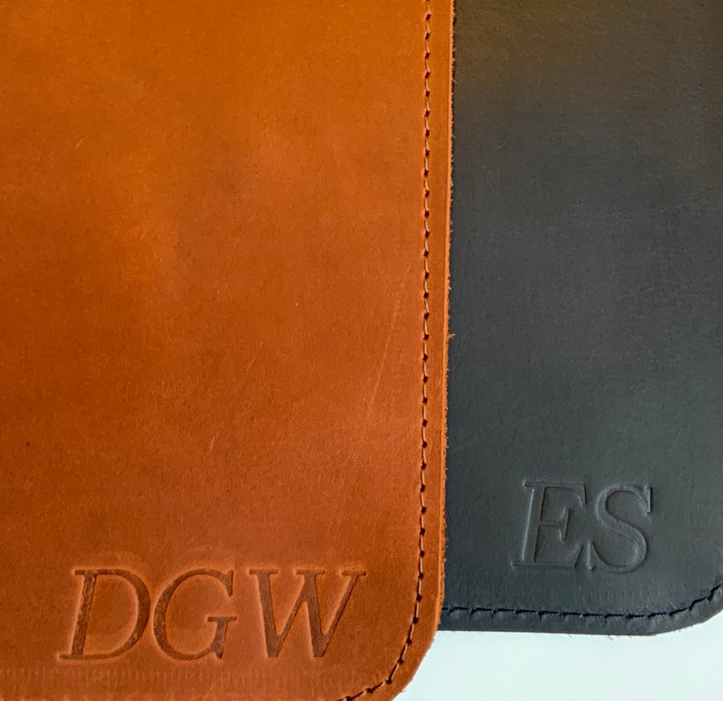 May include: Two brown leather wallets with stitched edges. The left wallet has the initials "DGW" embossed on the front. The right wallet has the initials "ES" embossed on the front.