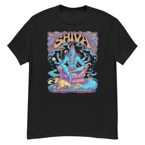 Puede incluir: Camiseta negra con una vibrante ilustración de la deidad hindú Shiva. La obra de arte representa a Shiva en una pose meditativa, rodeado de elementos psicodélicos coloridos. La palabra "Shiva" se muestra prominentemente encima de la figura, con el texto "GOD OF DESTRUCTION AND TRANSFORMATION" debajo.