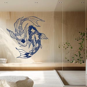 Può includere: Un bagno moderno dal design minimalista. Un grande murale di pesci koi blu adorna una parete in legno. La stanza presenta un lavabo in pietra, un grande specchio e un box doccia in vetro. Il pavimento è ricoperto da un tappeto chiaro.
