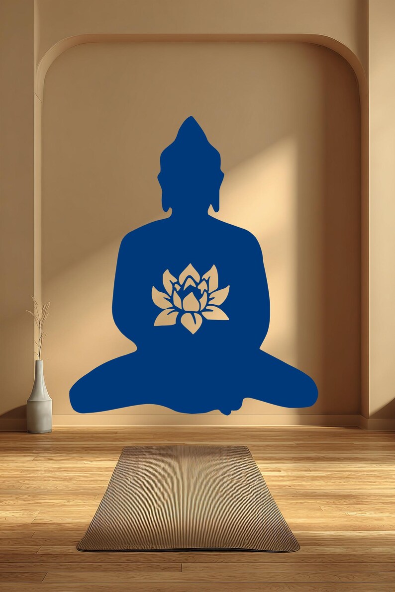 Puede incluir: Silueta azul de un Buda sentado con una flor de loto dorada en el pecho. La imagen est&aacute; en una pared beige con una esterilla de yoga en el suelo de madera. Un jarr&oacute;n con una planta est&aacute; a la izquierda.