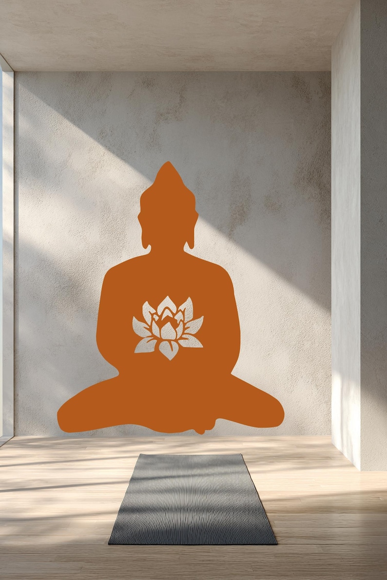 Puede incluir: Silueta naranja de un Buda sentado con una flor de loto en el pecho, sobre una pared texturizada. Una esterilla de yoga gris descansa sobre el suelo de madera, creando una est&eacute;tica serena y minimalista. La imagen evoca una sensaci&oacute;n de paz y atenci&oacute;n plena.