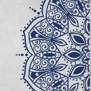 May include: A detailed, navy blue mandala design on a light gray background. The symmetrical pattern features intricate swirls, leaf shapes, and dotted accents, creating a visually appealing and balanced composition. The design is a partial view, showcasing the edge of the mandala.