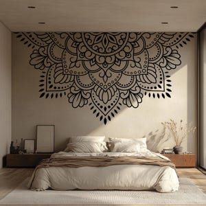 May include: A black mandala wall decal above a bed. The intricate design features floral and geometric patterns. The bedroom has a neutral color palette with a bed, nightstands, and a rug.