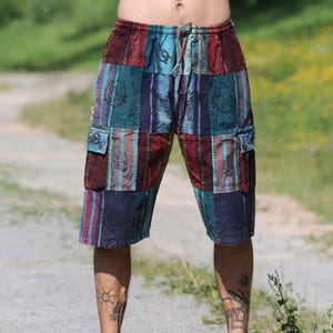 Könnte beinhalten: Patchwork-Shorts in Blau-, Burgunder- und Türkistönen mit Kordelzug und Cargotaschen. Die Shorts sind knielang und werden mit braunen Sandalen getragen. Das Bild enthält die Website-Adresse www.lacozy.de.
