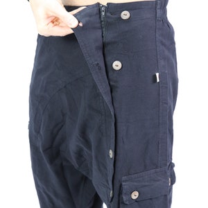 May include: Black cargo pants with a button fly and multiple pockets. The pants are open at the waist and the zipper is visible.