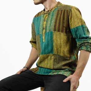 Puede incluir: Una camisa de manga larga con un diseño de patchwork con rayas en tonos verdes, amarillos y marrones.