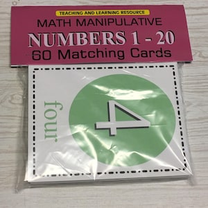 May include: A package of math manipulative matching cards for numbers 1-20. The cards are in a clear plastic wrapper. The top of the package has a pink header with the text "TEACHING AND LEARNING RESOURCE MATH MANIPULATIVE NUMBERS 1-20 60 MATCHING CARDS."