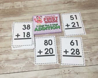 May include: A set of flashcards for first grade math featuring 2-digit plus 2-digit addition problems. The flashcards are white with black text and a black line for the answer. The text on the flashcards includes the following problems: 38 + 18, 51 + 21, 80 + 20, and 61 + 28.