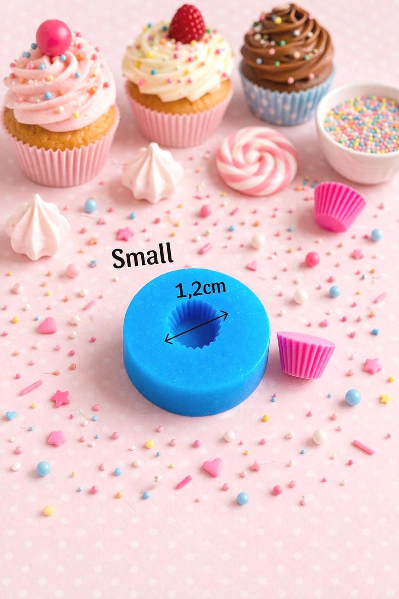 May include: A blue silicone mold with a 1.2 cm diameter, next to a pink cupcake liner and decorated cupcakes. The word "Small" is printed on the pink background. Sprinkles and meringue candies are scattered around.
